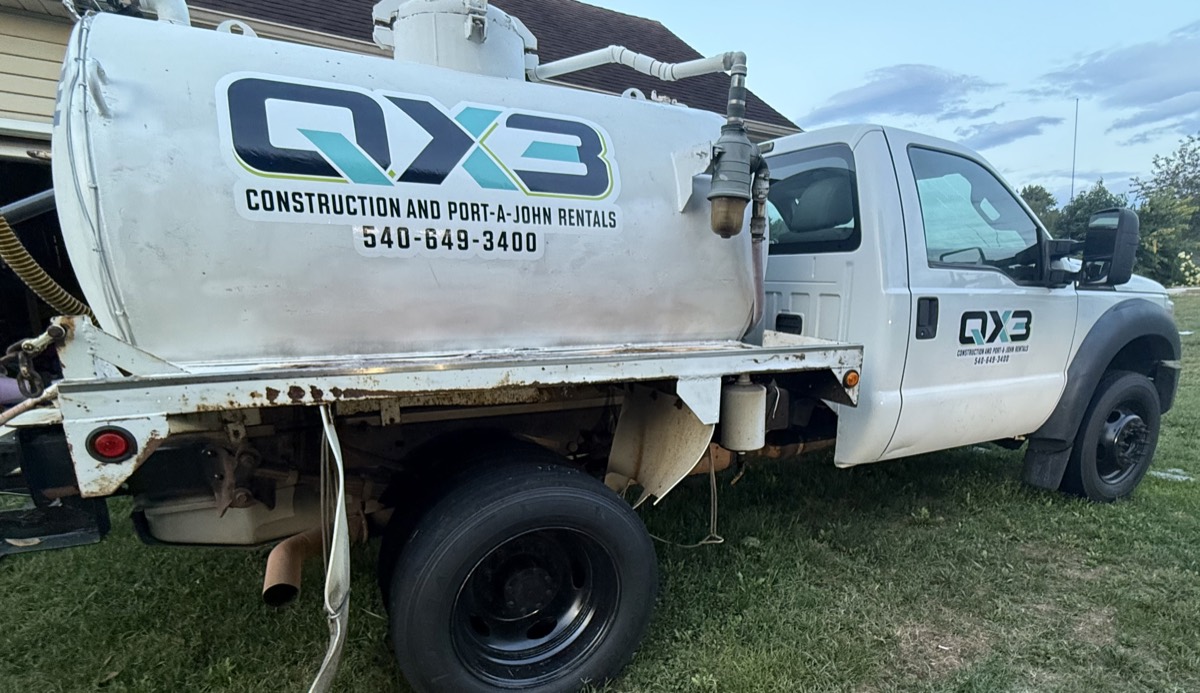 Rear view of the QX3 vacuum service truck showing the tank and pump